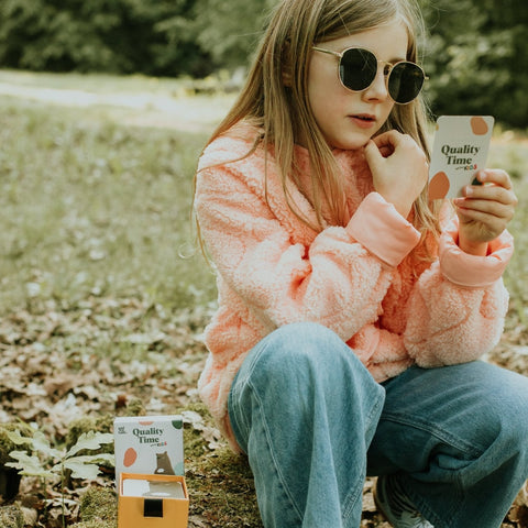 Dziewczynka na dworze z kartą Quality Time Kids